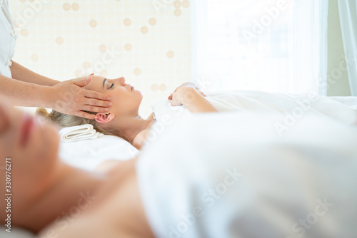 Concept of traditional thai massage relax and body health care .Beautiful caucasian woman receiving head and facial massage in spa salon.blonde beautiful girl enjoying a massage at the health spa.