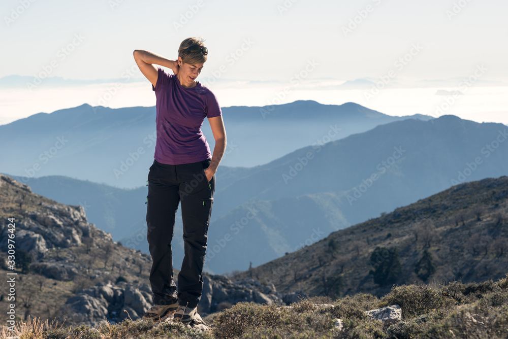Fototapeta premium Hiker woman doing stretching on top of the mountain.