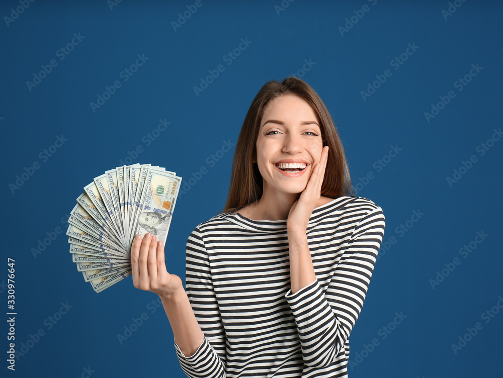 Happy young woman with cash money on blue background Happy young woman with cash money on blue background
