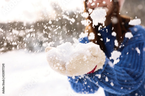 Young woman playing with snow outdoors, closeup. Winter vacation