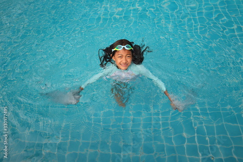 An asian girl smiles in the pool