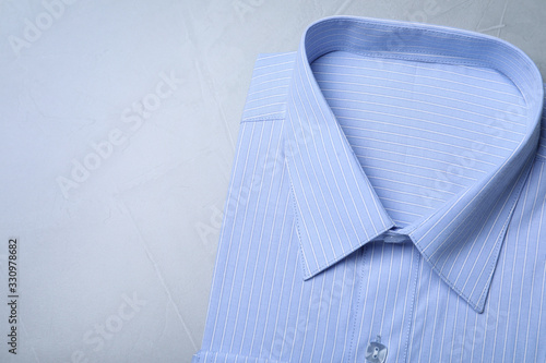 Stylish light blue shirt on grey background, top view with space for text. Dry-cleaning service