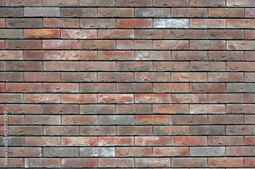 A brown brick wall with a decorated rough surface. Background