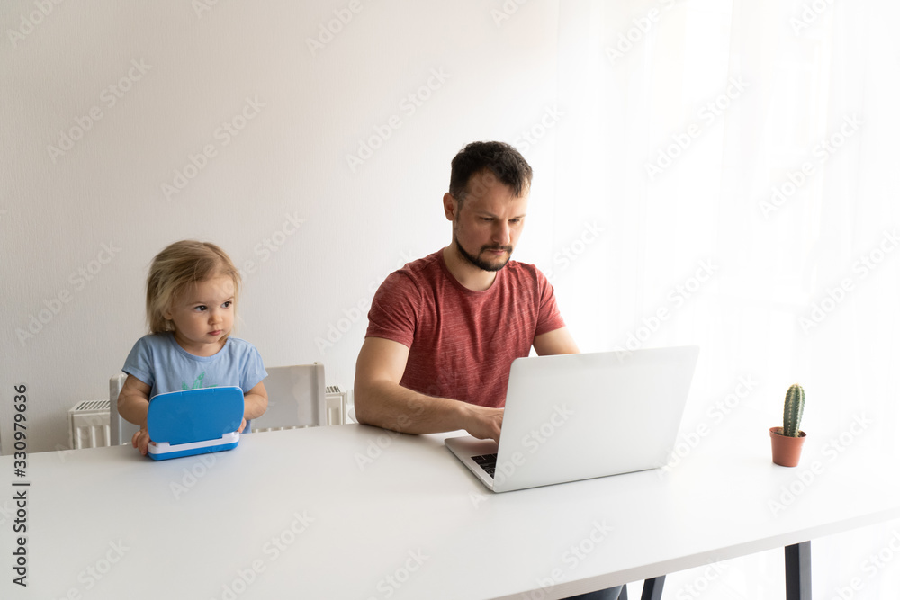 Young man, father should work from home during quarantine time cause of coronavirus. Child at home, kindergarden closed. Baby helps father to work. They work in laptops. White background. Young man, father should work from home during quarantine time cause of coronavirus. Child at home, kindergarden closed. Baby helps father to work. They work in laptops. White background.