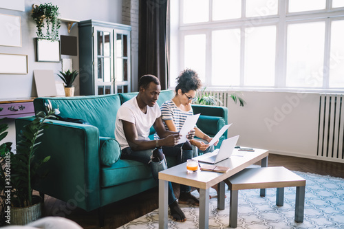 Busy black couple doing paperwork at home photo