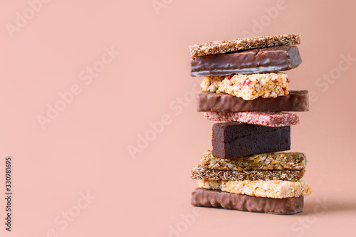 Different Energy protein bars and oatmeal bars on light brown chocolate background. Set of energy, sport, breakfast and protein bars. Copy space. Banner