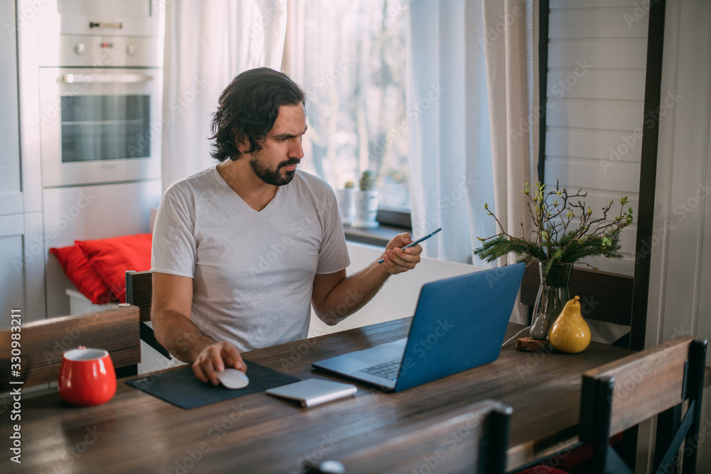Workplace at home. A man works at a laptop at home Workplace at home. A man works at a laptop at home