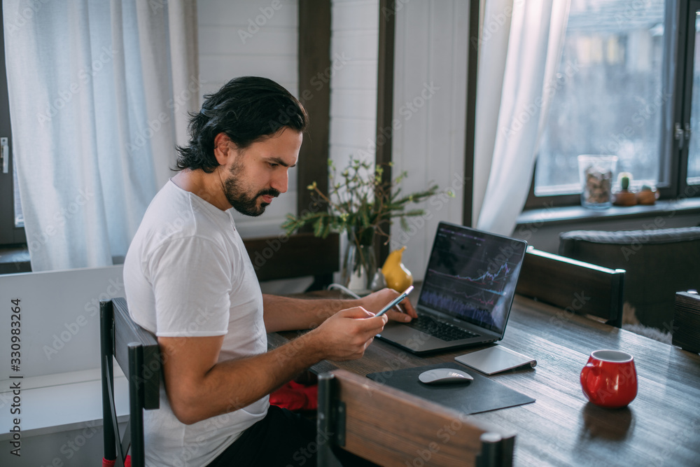 Workplace at home. A man works at a laptop at home Workplace at home. A man works at a laptop at home