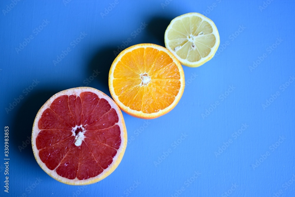 slices of orange Lemon and pink grapefruit on blue background slices of orange Lemon and pink grapefruit on blue background