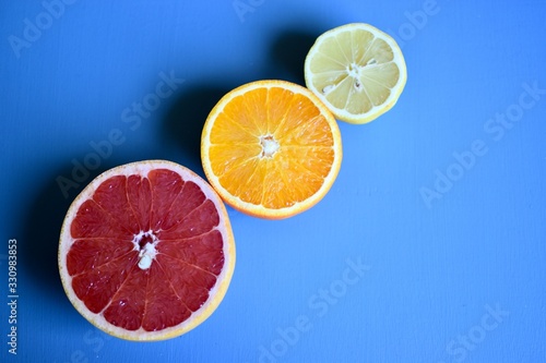 slices of orange Lemon and pink grapefruit on blue background