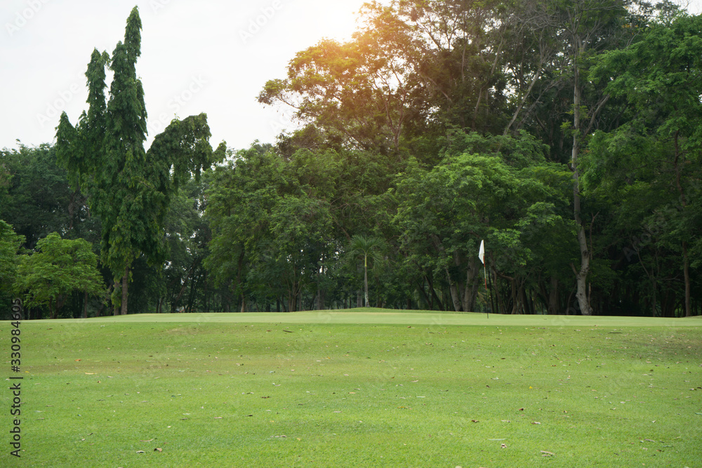 The evening golf course has sunlight shining down at golf course in Thailand