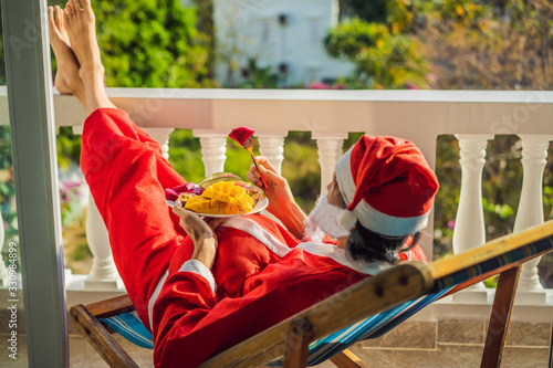 cheerful santa man hold exotic fruit. healthy gift. bearded man healthy eating. merry christmas. happy new year. xmas gifts and presents. winter season. holiday with vitanin photo