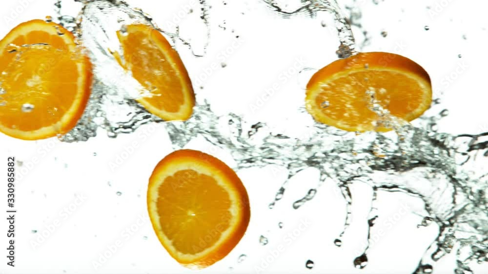 Super slow motion of orange slices with water splash on white background. Filmed on high speed cinema camera, 1000 fps. Super slow motion of orange slices with water splash on white background. Filmed on high speed cinema camera, 1000 fps.