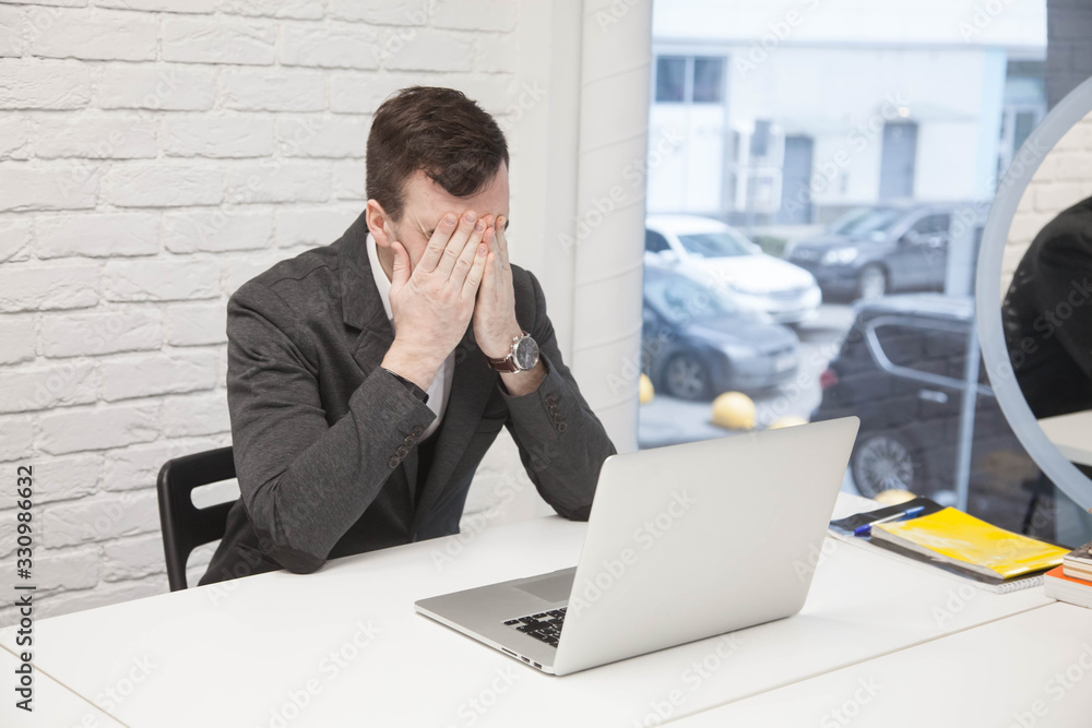 young businessman works in an office with a laptop young businessman works in an office with a laptop