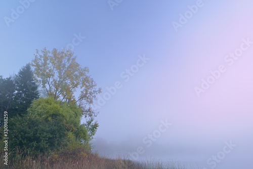 Autumn landscape at dawn of the shoreline of Whitford Lake in fog, Fort Custer State Park, Michigan, USA © Dean Pennala