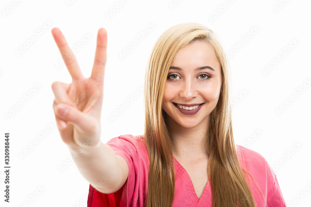 Portrait of cute young female nurse wearing scrubs showing peace Portrait of cute young female nurse wearing scrubs showing peace
