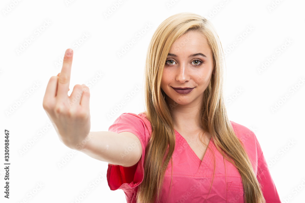 Portrait of young female nurse wearing scrubs showing obscene gesture Portrait of young female nurse wearing scrubs showing obscene gesture