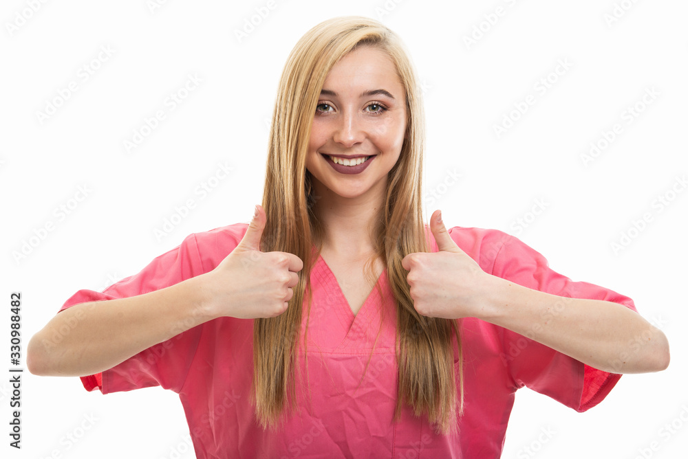 Portrait of young female nurse wearing scrubs showing double like Portrait of young female nurse wearing scrubs showing double like