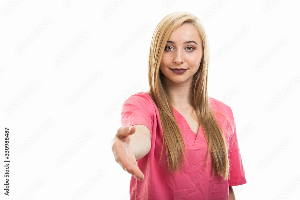 Portrait of young female nurse wearing scrubs offering hand shake Portrait of young female nurse wearing scrubs offering hand shake