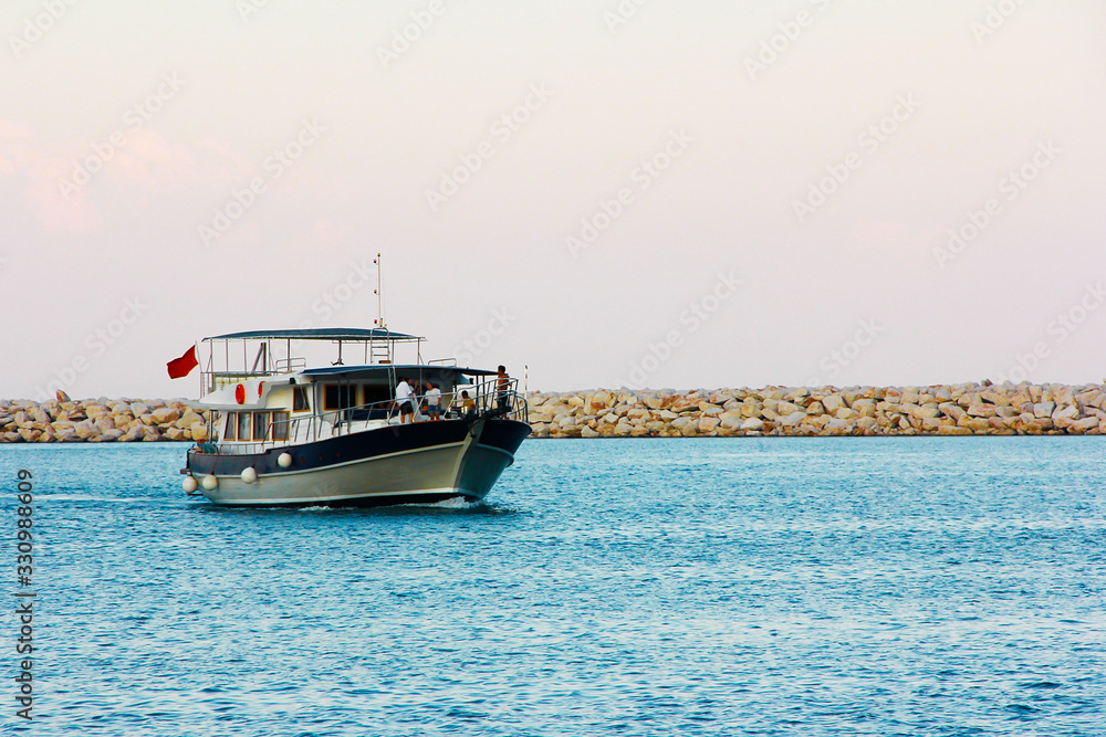 pleasure boat on the waves of the blue sea in the evening pleasure boat on the waves of the blue sea in the evening