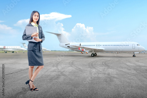 Asian businesswoman standing while carrying a laptop