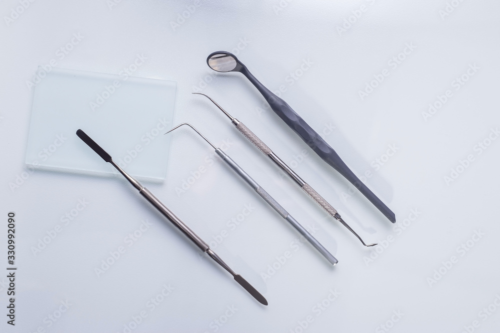 top view, medical dental instruments, on a sterile subject table of a dentist doctor. Near the dummy of human jaws and teeth. Medical Flatlay top view, medical dental instruments, on a sterile subject table of a dentist doctor. Near the dummy of human jaws and teeth. Medical Flatlay