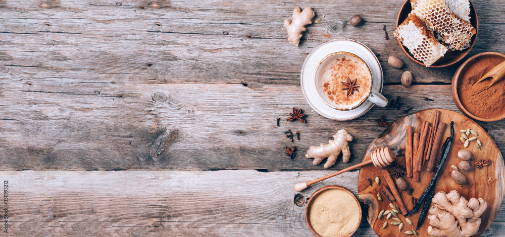 Tea with milk, cloves, ginger, cardamom, cinnamon, anise, vanile, honey, nutmeg. Indian masala tea with spices. Top view, copy space. Antiviral beverage. Healthy ayurvedic spice drink chai Tea with milk, cloves, ginger, cardamom, cinnamon, anise, vanile, honey, nutmeg. Indian masala tea with spices. Top view, copy space. Antiviral beverage. Healthy ayurvedic spice drink chai