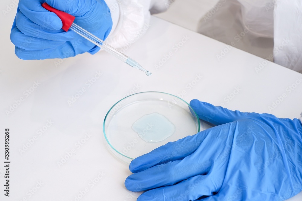 Researchers wear sterile gloves in the microbiology laboratory to