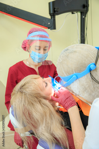 The dentist performs manipulations with the patient with an assistant