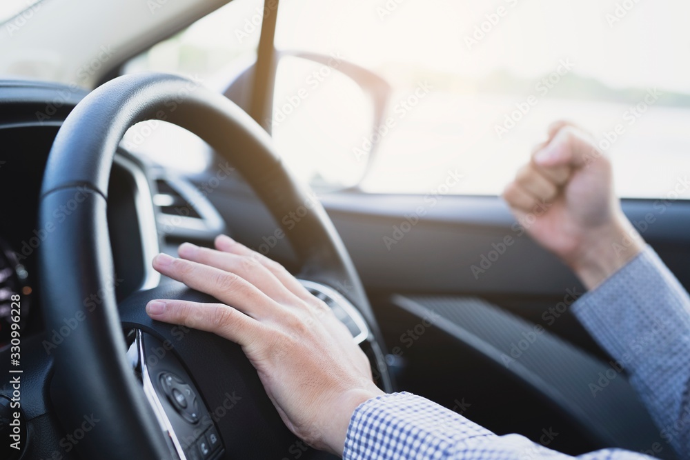 image of young man in a car, fist pump