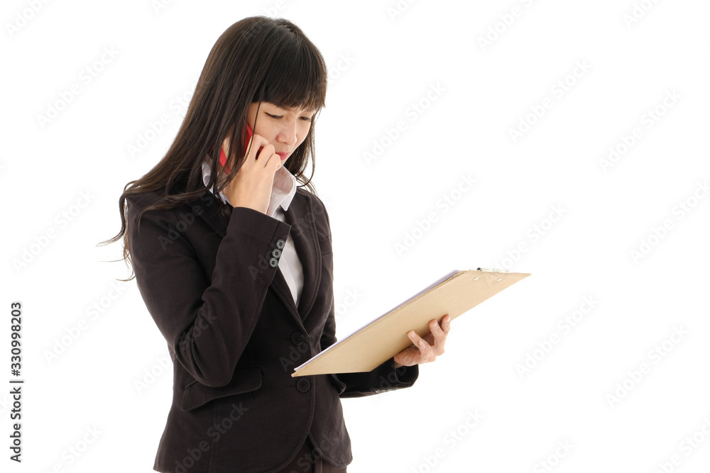Young Asian business woman in black suit with long hair holding document on clipboard and talking on mobile phone on white background. Serious business woman looking at documents,studio isolated. Young Asian business woman in black suit with long hair holding document on clipboard and talking on mobile phone on white background. Serious business woman looking at documents,studio isolated.