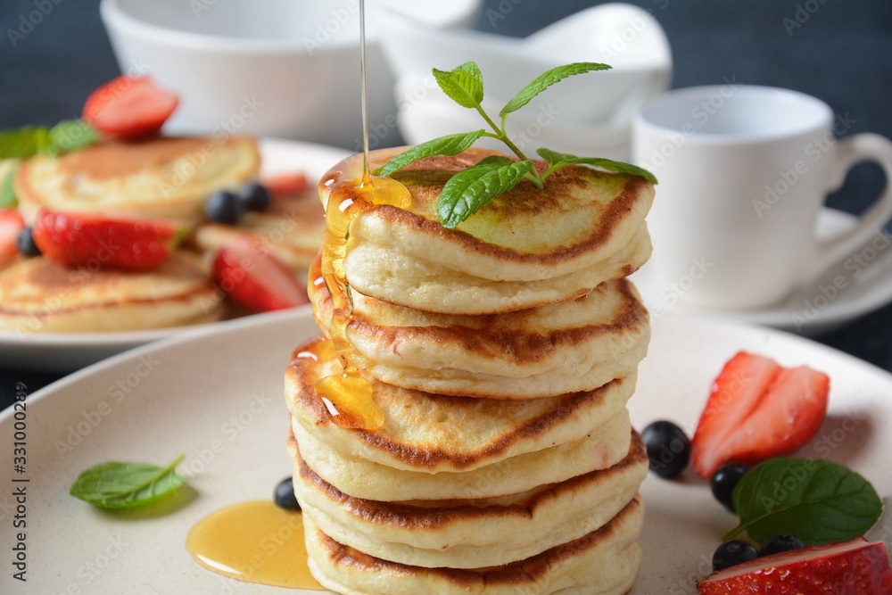 Sweet pancakes served with fresh blueberries , mint, strawberries,organic agave syrup. Healthy breakfast concept Sweet pancakes served with fresh blueberries , mint, strawberries,organic agave syrup. Healthy breakfast concept