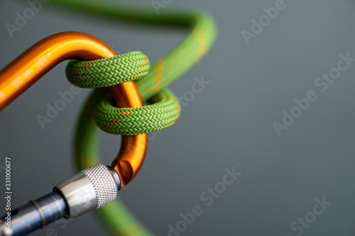 green rope wrapped around orange carabiner photo
