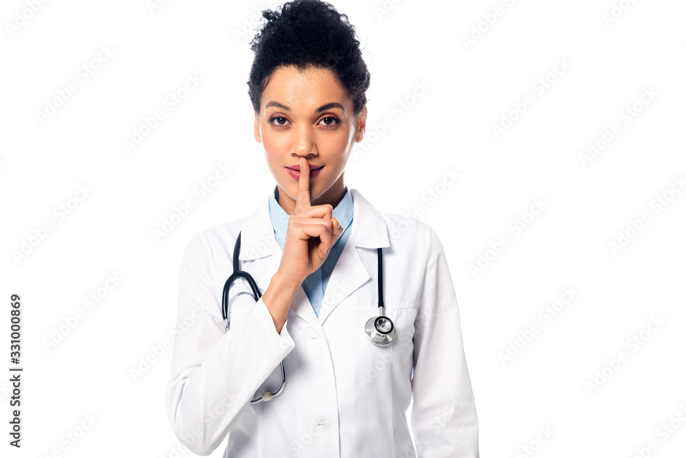 Front view of african american doctor with stethoscope showing quiet and looking at camera isolated on white Front view of african american doctor with stethoscope showing quiet and looking at camera isolated on white