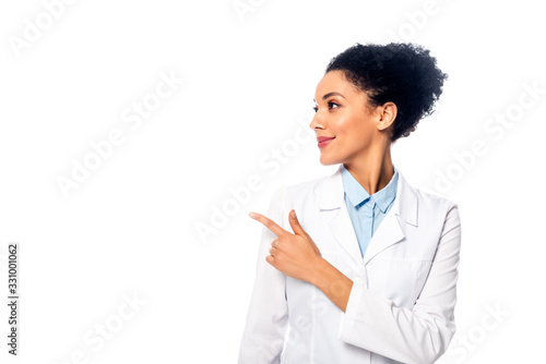 Front view of african american doctor smiling and pointing aside isolated on white photo