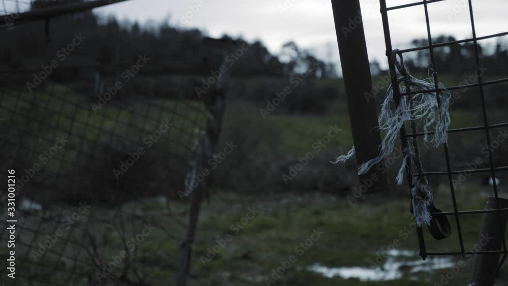 Tattered Metal String Of The Broken Gate Surrounded The Green Lawn In Northern part Of Ireland. -medium shot Tattered Metal String Of The Broken Gate Surrounded The Green Lawn In Northern part Of Ireland. -medium shot