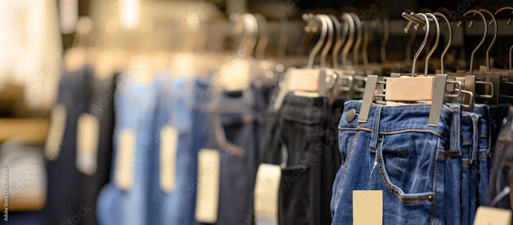 Jeans or Denim pants (trousers) hanging on rack in clothes shop. Fashion  product collection in clothing store for selling. Textile industry and  business concept Stock Photo | Adobe Stock