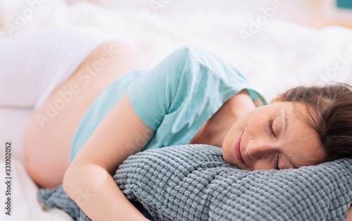Young pregnant woman resting in her room at home