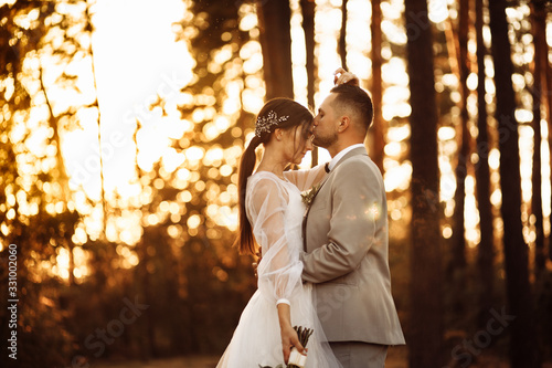 Perfect wedding couple on sunset in the autumn forest 