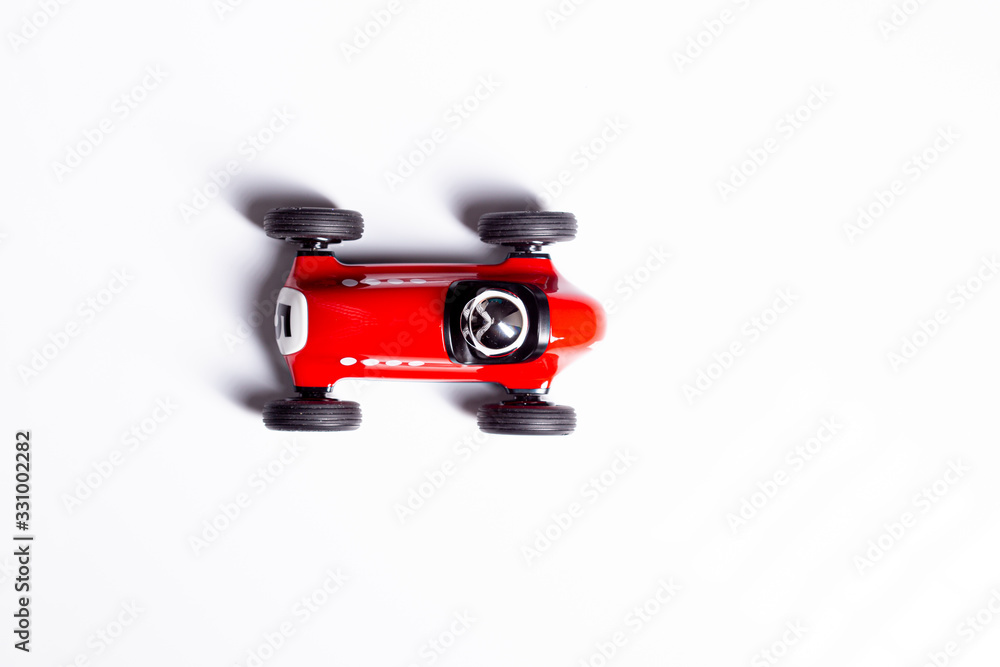 Red toy vintage racing car close up still isolated on a white background