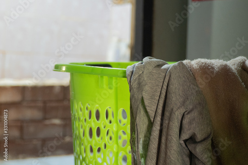 Unwashed clothes on a light green plastic basket