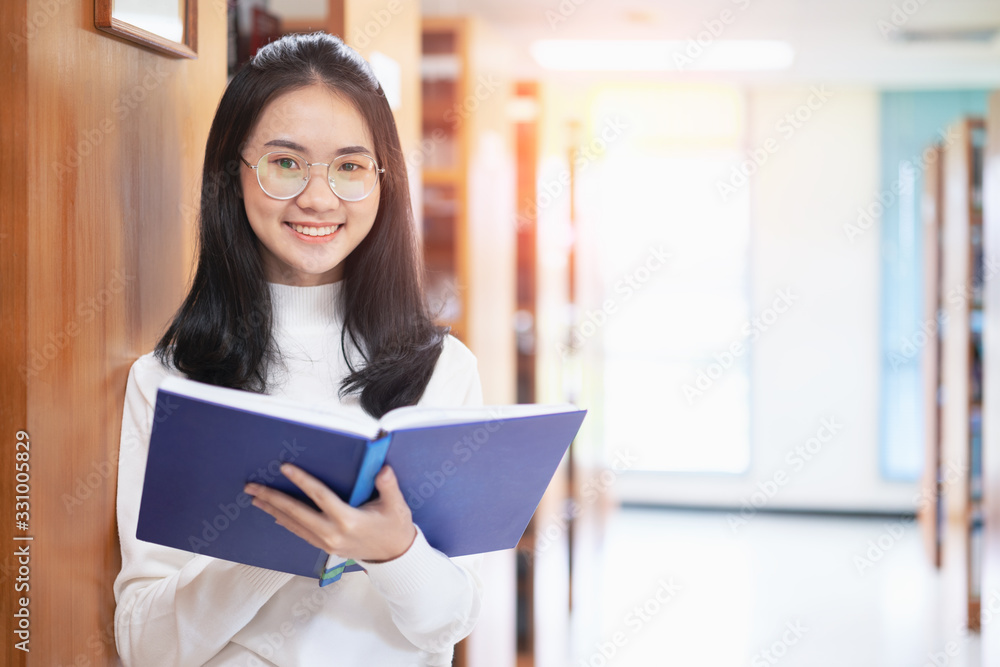 Back to school education knowledge college university concept, Beautiful female college student holding her books smiling happily standing in library, Learning and education concept