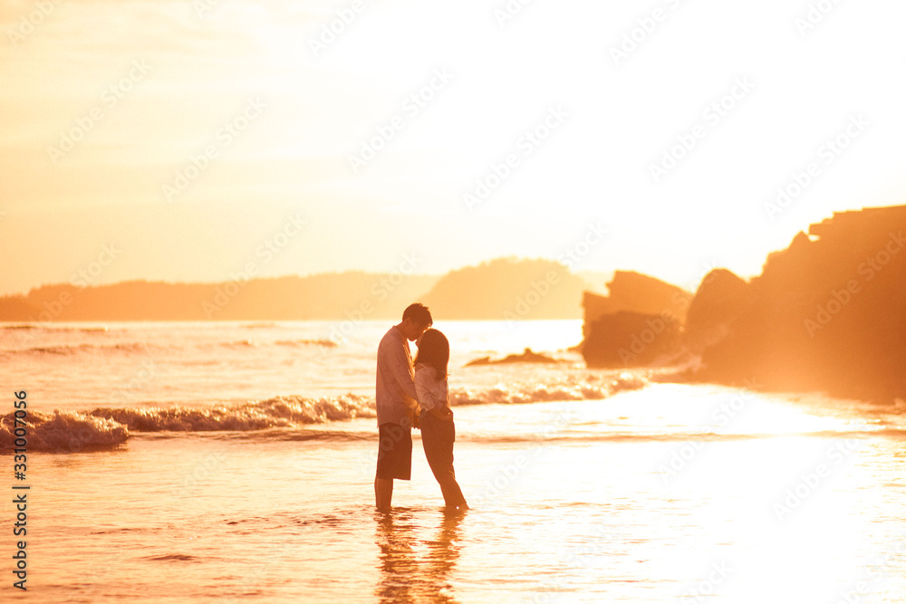 Couples kissing each other at the ocean.