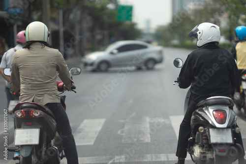 Two motorcycles on waiting zebra crossing traffic road