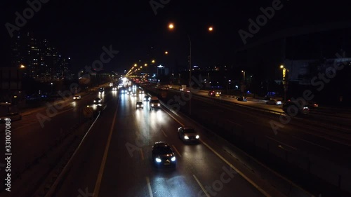 Traffic at night time at The E5 highway. Fikirtepe and Unalan neighborhood and skyscrapers located in Istanbul. 