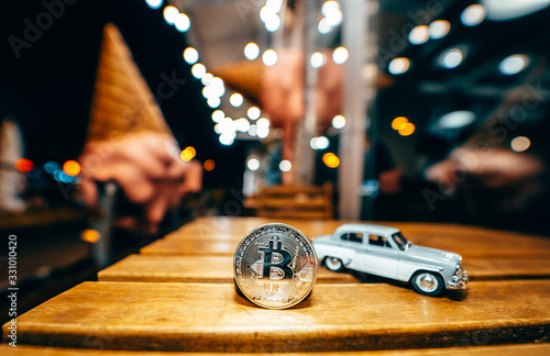 Silver bitcoin and Moskvich 401 on the table, glowing background photo