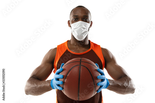 Beat the disease. Basketball player with ball in protective mask. Prevention of pneumonia respiratory symptoms such as fever, headache, cough. Chinese coronavirus. Healthcare, medicine, sport concept. photo