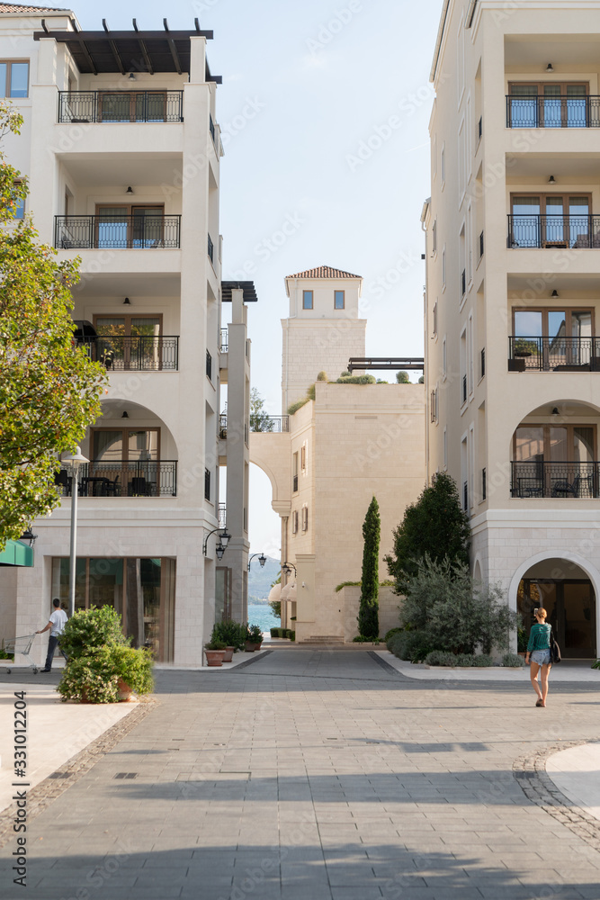 Obraz premium The facade of a modern white building with arches and balconies. Cityscape.