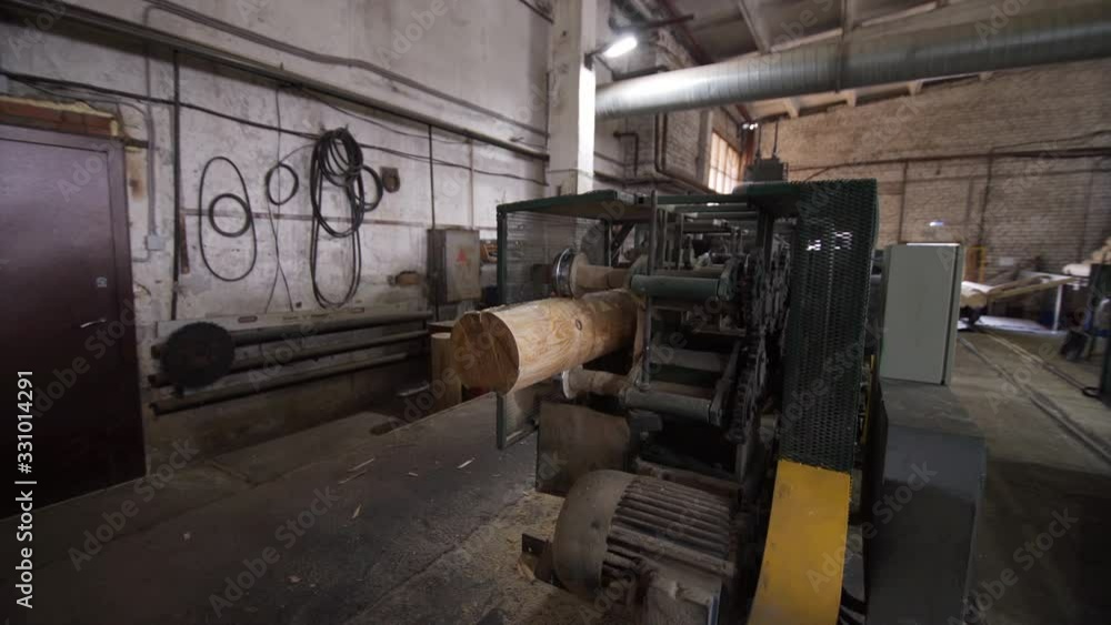 Dolly shot of Processing of round timber logs for building wooden house. Removing bark from logs using a machine. Pattern of logs. Woodworking factory. Dolly shot of Processing of round timber logs for building wooden house. Removing bark from logs using a machine. Pattern of logs. Woodworking factory.