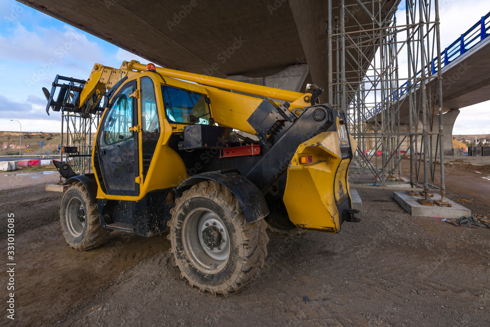 Forklift in a construction site performing an overpass in the construction of a road